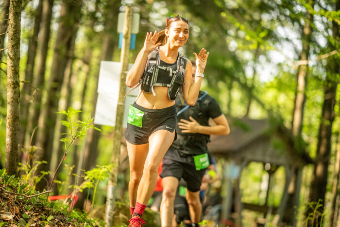 Une femme souriante qui court le Trail du Coureur des Bois de Duchesnay (photo : Louis Charland)